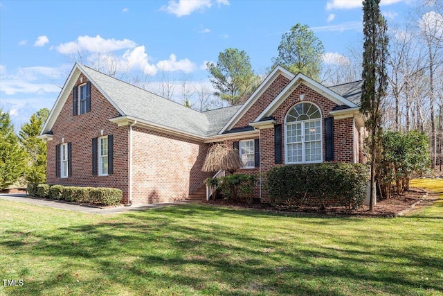 view of front facade with brick siding and a front lawn