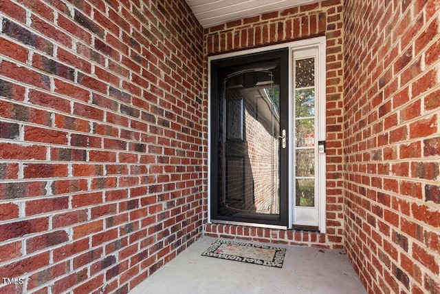 property entrance featuring brick siding