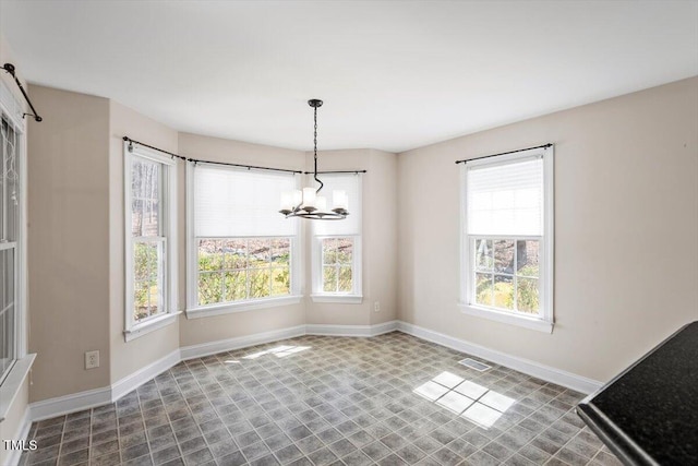 unfurnished dining area featuring visible vents, baseboards, and an inviting chandelier