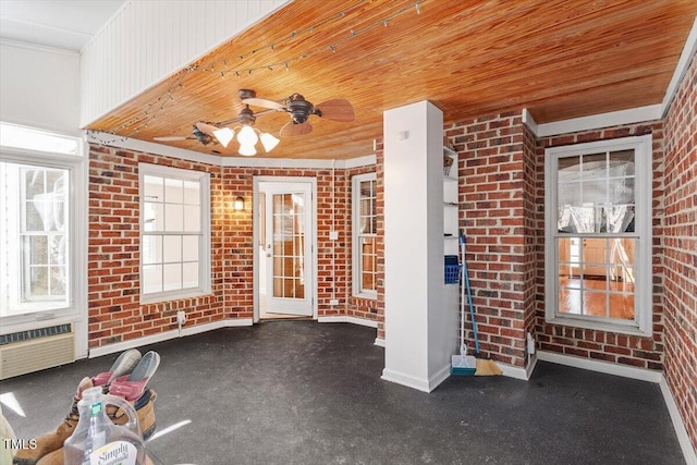 unfurnished sunroom featuring wood ceiling, a wall mounted air conditioner, and ceiling fan