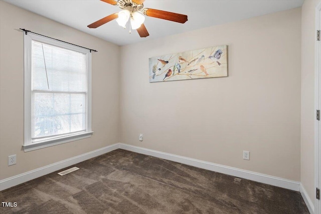 unfurnished room featuring dark colored carpet, visible vents, ceiling fan, and baseboards