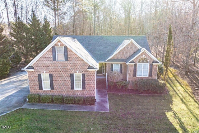 view of front facade with a front yard and brick siding