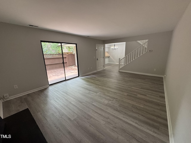 159 Finley Forest Dr, Chapel Hill, NC 27517 - unfurnished living room with a chandelier, wood finished floors, baseboards, and stairs