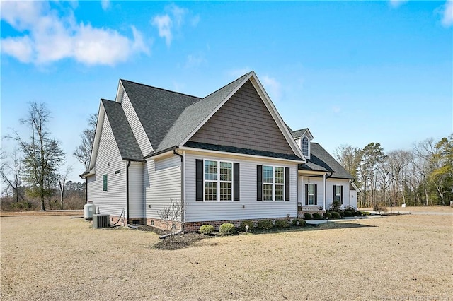 exterior space with a shingled roof, crawl space, and central AC