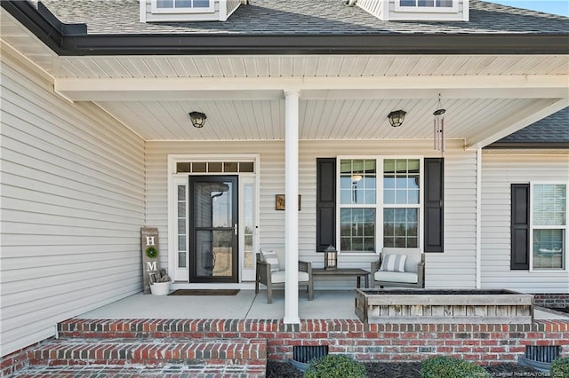 property entrance featuring a porch and a shingled roof