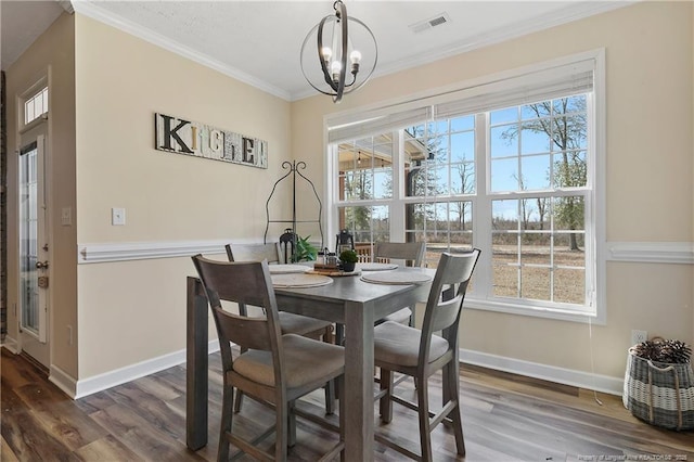 dining room with baseboards, dark wood-style flooring, and crown molding