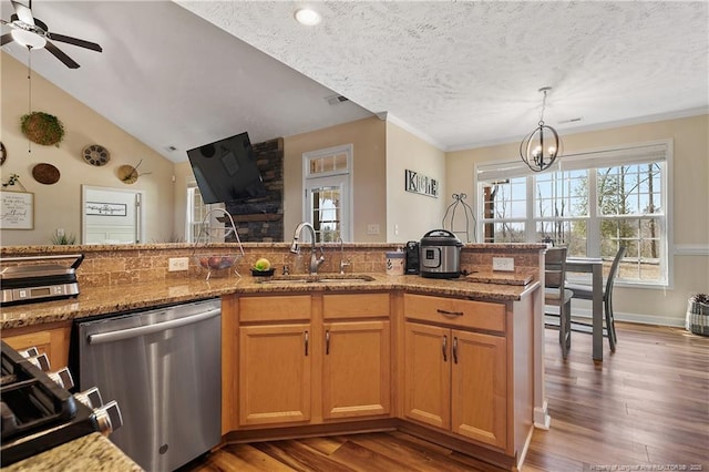 kitchen featuring a sink, a textured ceiling, dishwasher, and wood finished floors