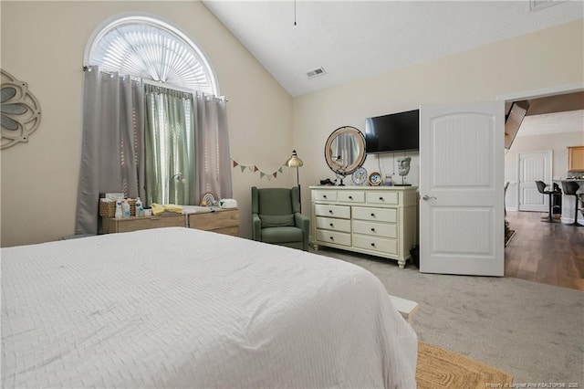 bedroom with visible vents, vaulted ceiling, and carpet flooring