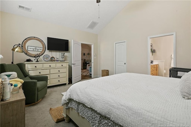 carpeted bedroom with high vaulted ceiling, visible vents, and ensuite bathroom