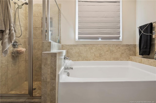 bathroom with a shower stall and a bath