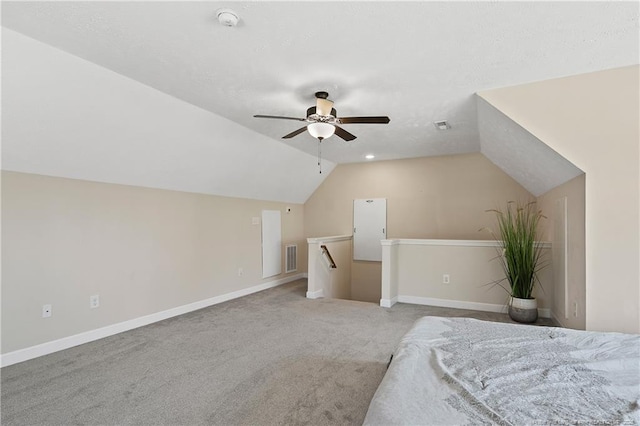 unfurnished bedroom with vaulted ceiling, carpet floors, visible vents, and baseboards