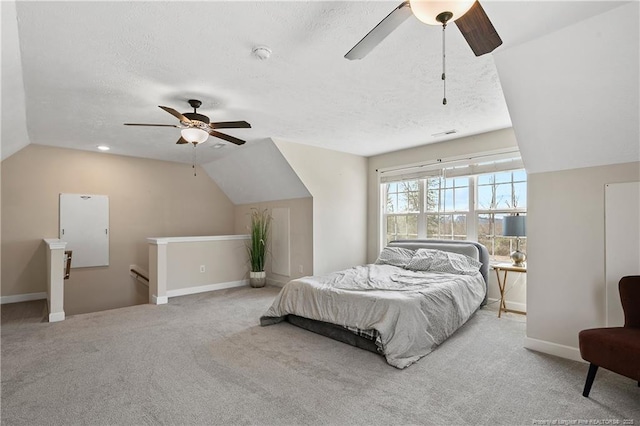 bedroom with carpet, baseboards, vaulted ceiling, and a textured ceiling