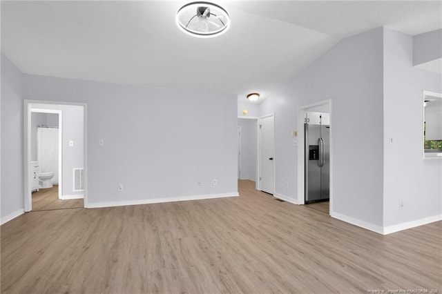 unfurnished living room featuring lofted ceiling, light wood finished floors, baseboards, and visible vents