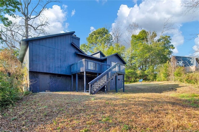 rear view of house with a wooden deck and stairs