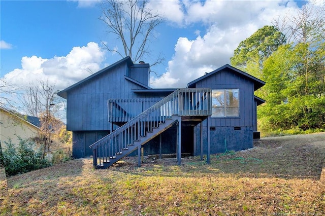 back of property featuring crawl space, a chimney, a wooden deck, and stairs