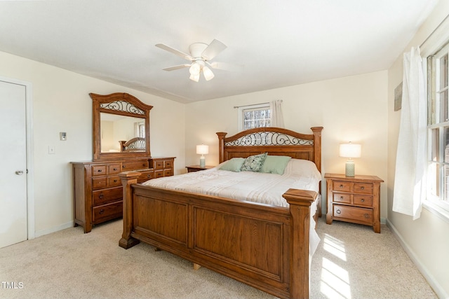 bedroom featuring a ceiling fan, light carpet, and baseboards