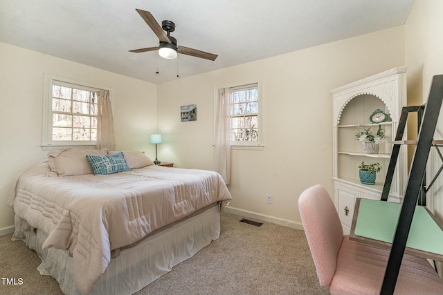 bedroom with light colored carpet, visible vents, baseboards, and multiple windows