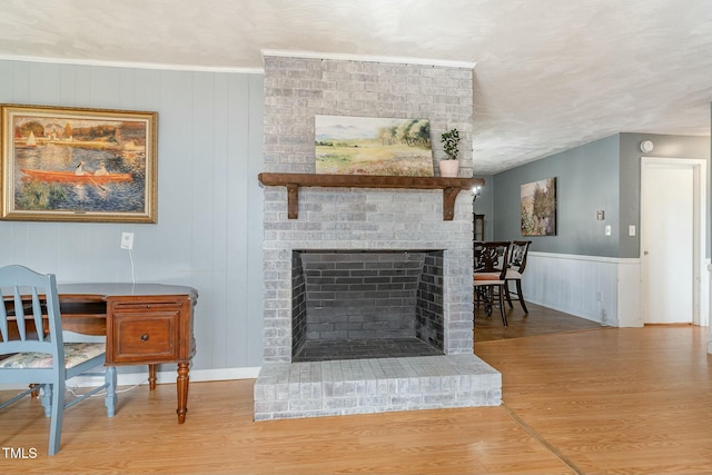 living room featuring a brick fireplace and wood finished floors