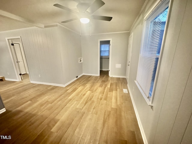 empty room featuring a ceiling fan, light wood-type flooring, crown molding, and baseboards