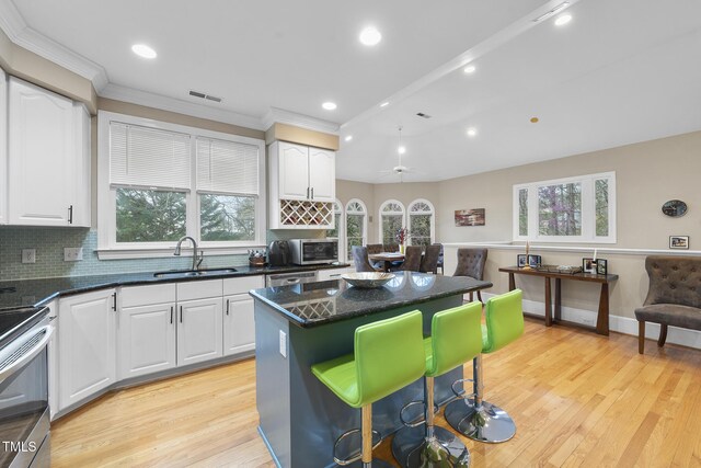 104 Sierra Dr, Chapel Hill, NC 27514 - kitchen with white cabinetry, a kitchen bar, a kitchen island, and a sink