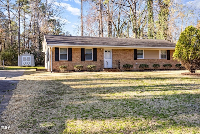 ranch-style home featuring brick siding, an outdoor structure, a front lawn, and a storage unit