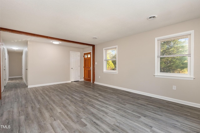 unfurnished room with visible vents, baseboards, and wood finished floors