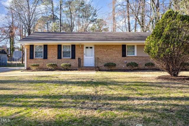 ranch-style house with a front yard and brick siding