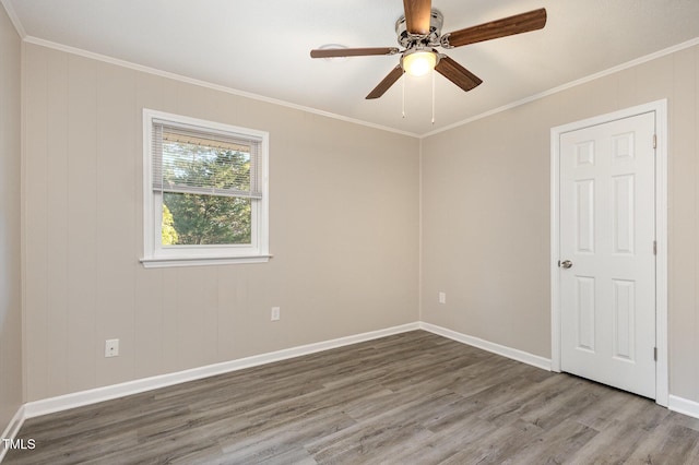 spare room featuring a ceiling fan, baseboards, ornamental molding, and wood finished floors