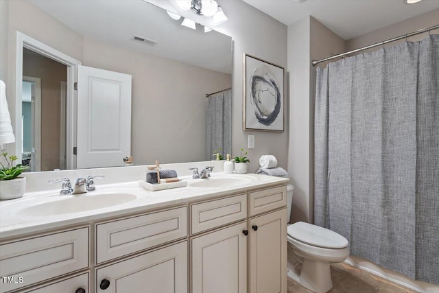 bathroom featuring tile patterned flooring, visible vents, toilet, and a sink