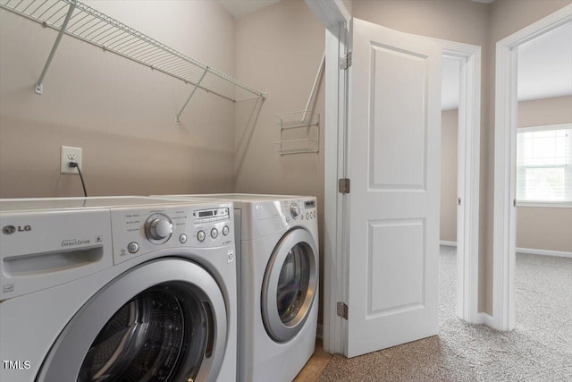 laundry area with laundry area, light carpet, baseboards, and washer and clothes dryer