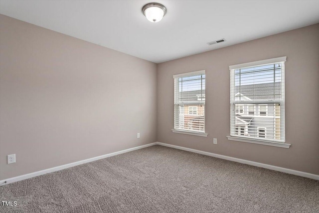 carpeted spare room featuring visible vents and baseboards