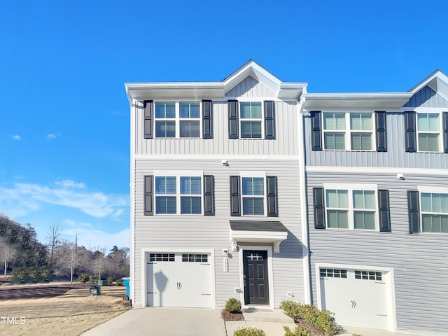 townhome / multi-family property featuring board and batten siding, driveway, and a garage