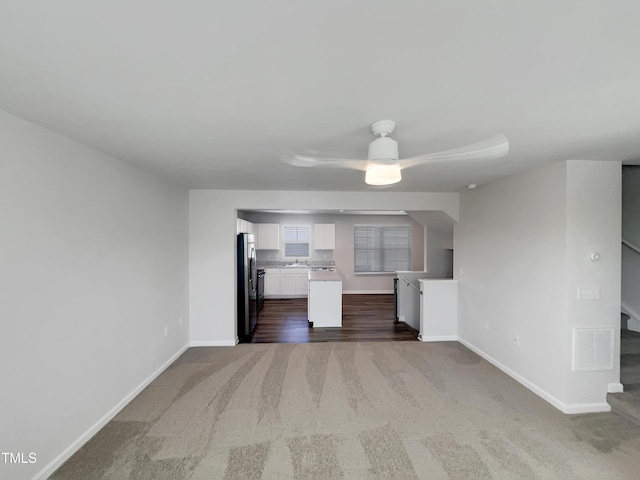 kitchen with visible vents, white cabinetry, open floor plan, freestanding refrigerator, and dark carpet