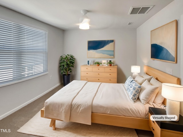 carpeted bedroom featuring a ceiling fan, visible vents, and baseboards