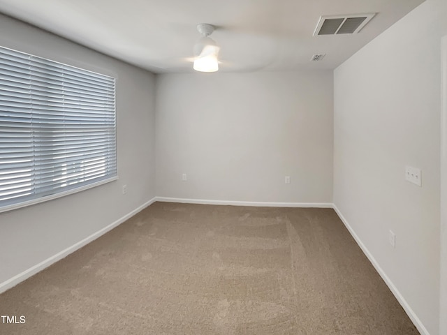 carpeted spare room with baseboards and visible vents