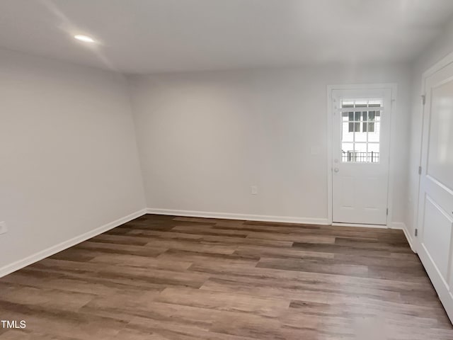 empty room with recessed lighting, baseboards, and wood finished floors