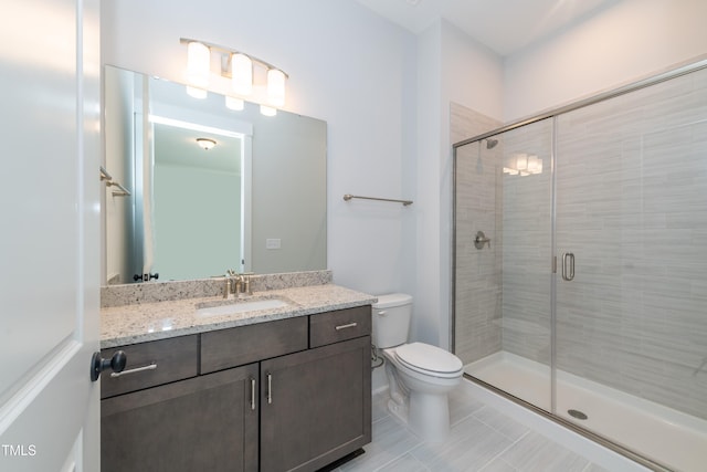 full bath featuring a stall shower, vanity, and toilet