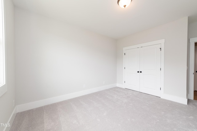 unfurnished bedroom featuring a closet, carpet flooring, and baseboards