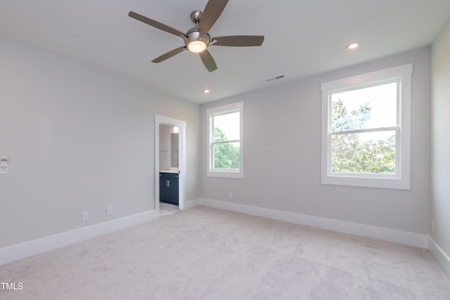 empty room with recessed lighting, light colored carpet, visible vents, and baseboards