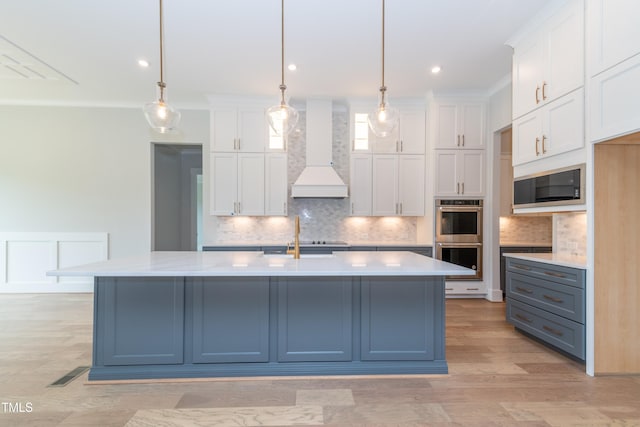 kitchen featuring light countertops, premium range hood, black appliances, and white cabinetry