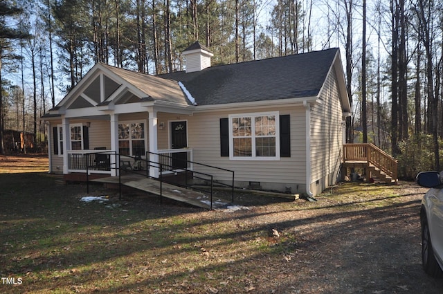 view of front of house with a porch, crawl space, a shingled roof, and a chimney