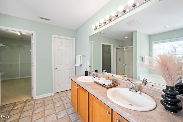 full bath with double vanity, a sink, visible vents, and a shower stall