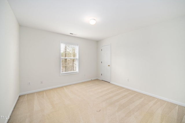 spare room featuring carpet flooring, visible vents, and baseboards