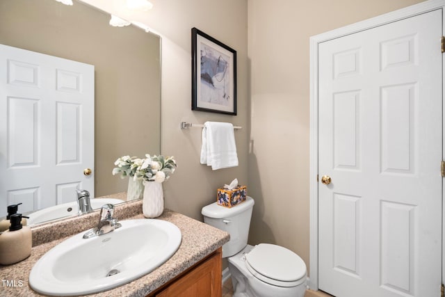 half bathroom with vanity and toilet