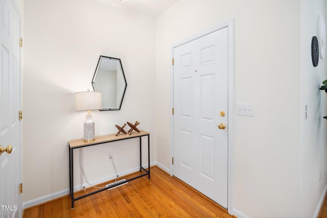 foyer entrance with light wood-type flooring and baseboards