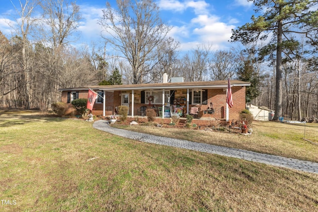 single story home featuring a porch, brick siding, a chimney, and a front lawn