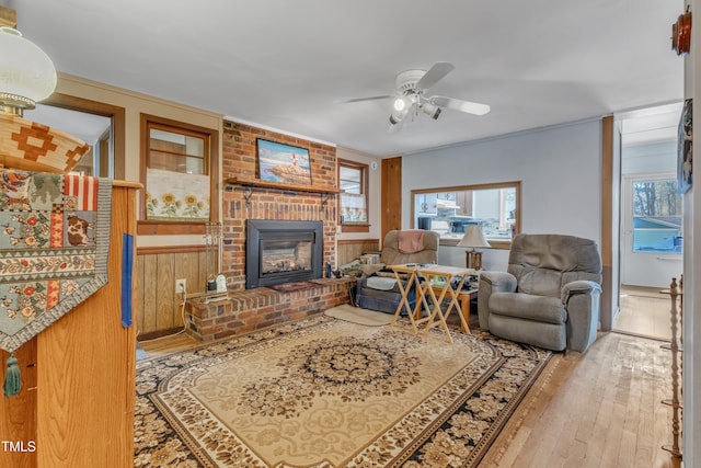 living room featuring ceiling fan, hardwood / wood-style floors, and a fireplace