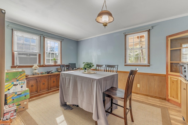 dining space with ornamental molding, a wealth of natural light, a wainscoted wall, and cooling unit