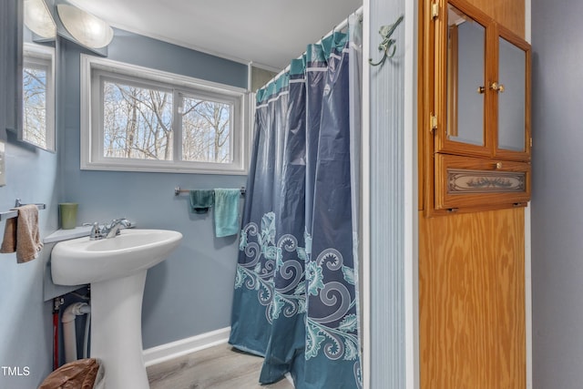 bathroom with a shower with curtain, a sink, baseboards, and wood finished floors