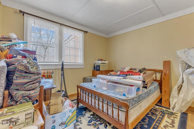 bedroom with wood finished floors and crown molding